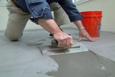 Using a trowel to apply a final layer of floor leveler